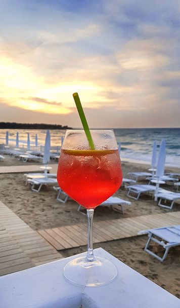 Cocktail Aperol Spritz on the background of beach with sun loungers and umbrellas, Puglia, Italy - Photo, Image