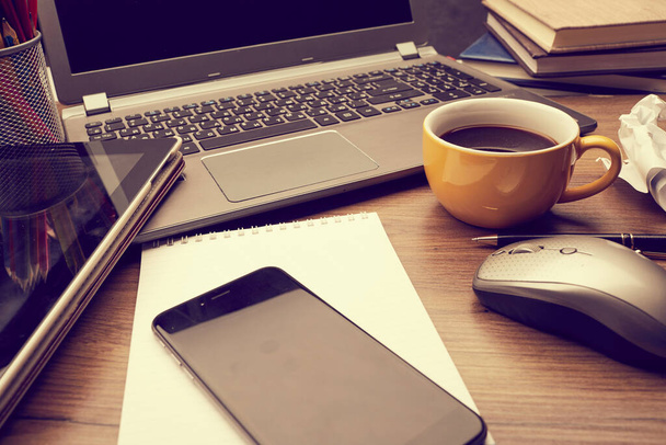 office table with cup of coffee and notebook with laptop and smartphone - Photo, Image