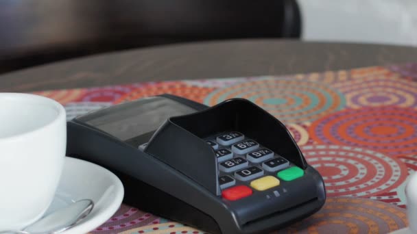 Hombre joven en la cafetería está pagando el precio mediante el uso de un teléfono inteligente y terminal
 - Imágenes, Vídeo