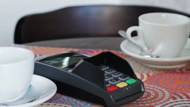 Mujer de negocios en chaqueta blanca en la cafetería está pagando el precio mediante el uso de un teléfono inteligente y terminal
 - Imágenes, Vídeo