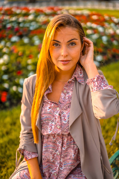 Summer lifestyle. Portrait of young woman near flowerbed - Photo, Image
