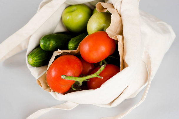 Cotton bag with fresh bright vegetables on a light background. - Foto, Bild