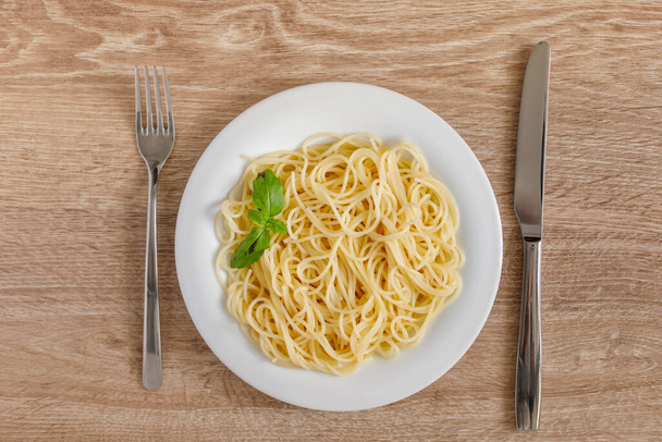 Spaghetti on a plate top view on a wooden background - Photo, image