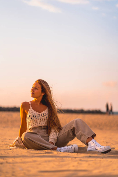 Summer lifestyle. Portrait of young woman on a beach at sunset. - Photo, Image