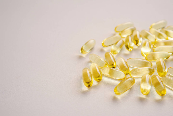 Fish oil capsules. Omega nutrition, vitamin pills on neutral backdrop. Medical supplement tablets for health care with empty space for text. - Foto, Imagem