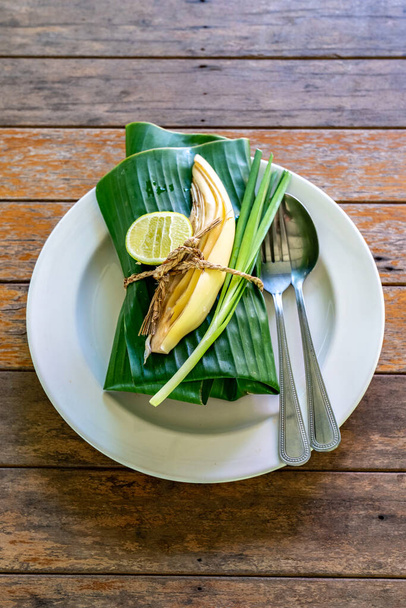Накрытая банановым листом тайская еда готова к подаче. Внутри банановый лист является PadThai, традиционный Таиланд Жареная лапша с креветками
. - Фото, изображение
