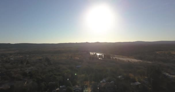 Αεροφωτογραφία μιας κοιλάδας με κορυφή δέντρου μια μικρή λιμνοθάλασσα και ο ήλιος ανατέλλει στην Κόρδοβα της Αργεντινής - Πλάνα, βίντεο