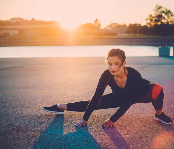 Lichaamspositieve vrouw doet fitness oefening buiten. - Foto, afbeelding