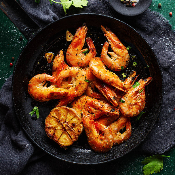 Roasted shrimps with spices and garlic served on pan on dark background. Square.  - Foto, immagini