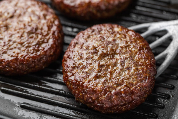 Closeup of meat beef patties grilled on pan. Cooking process - Foto, immagini