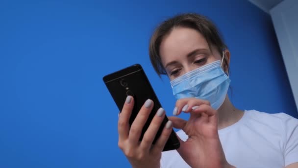 Retrato de mulher usando máscara facial médica e usando smartphone - câmera lenta
 - Filmagem, Vídeo