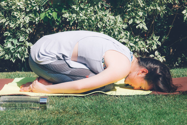 Mulher está fazendo ioga no jardim
 - Foto, Imagem