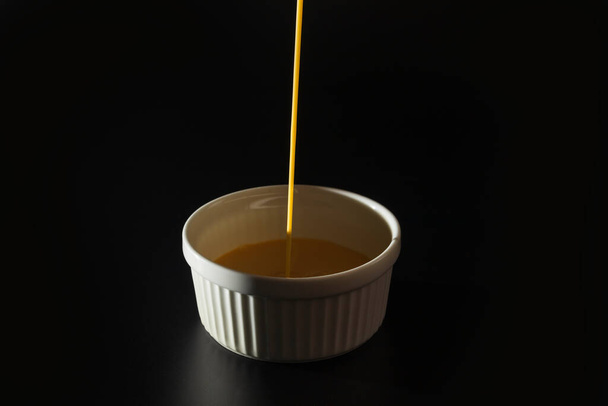 Un- pečení creme brulee recept dát do bílé ramekin na černém pozadí s kopírovacím prostorem. - Fotografie, Obrázek