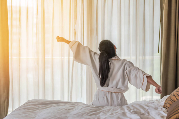 Buenos días despertar con la mujer asiática relajarse en la habitación del hotel
  - Foto, imagen