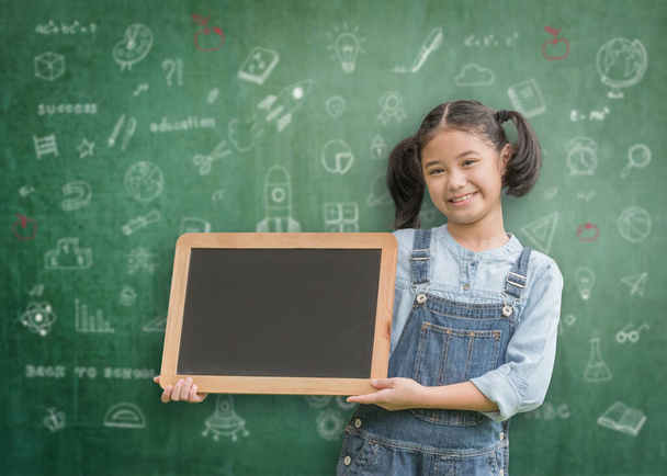 National back to school month, educational inspiration concept with Asian kid holding teacher classroom chalkboard with copyspace - Photo, Image