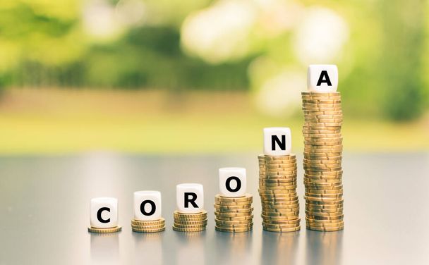 Corona salgınından kaynaklanan harcamaların artması için sembol. Zar, yükselen bozuk para yığınları üzerinde "Corona" ifadesini oluşturur. - Fotoğraf, Görsel