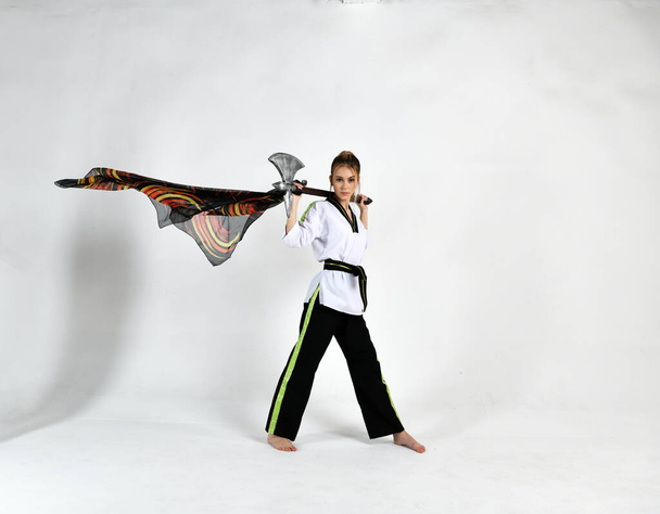 beautiful girl in white does kung fu training poses with fighting swords - Fotografie, Obrázek