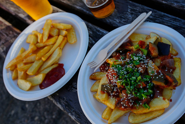 Street Food: Bratkartoffeln, Pommes mit gebackenem Gemüse, Schnittlauch und Sesam - Foto, Bild