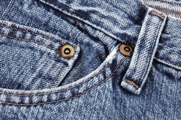 Jeans blu dettaglio primo piano che mostra tasca anteriore e cinturino e passante per cintura e borchie
 - Foto, immagini