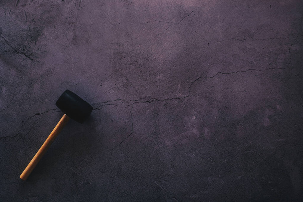 Flat lay of a hammer against a cracked concrete background with plenty of copy space - Photo, Image