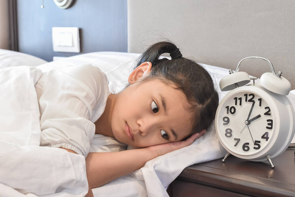 Asiatique fille enfant au lit ne pas dormir souffrant d'insomnie (trouble du sommeil) la nuit dans la chambre - Photo, image