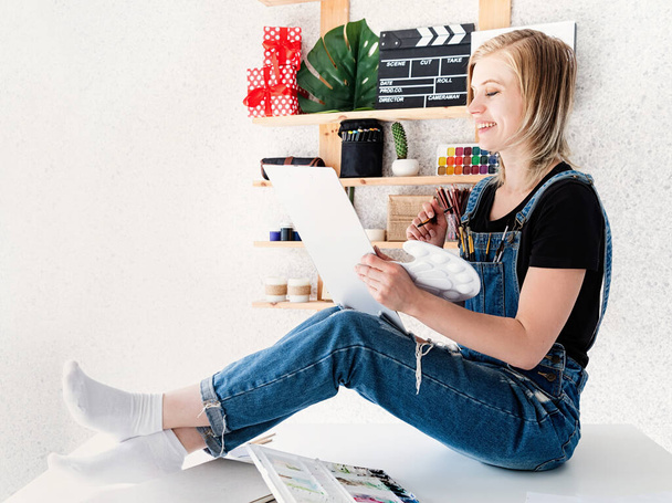 Ridendo artista femminile disegno a casa seduta sulla scrivania
 - Foto, immagini