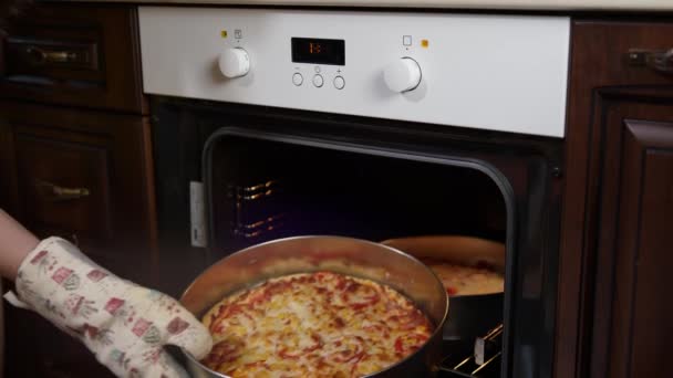 Pizza recién horneada con salchichas y tomates se retira del horno
. - Metraje, vídeo