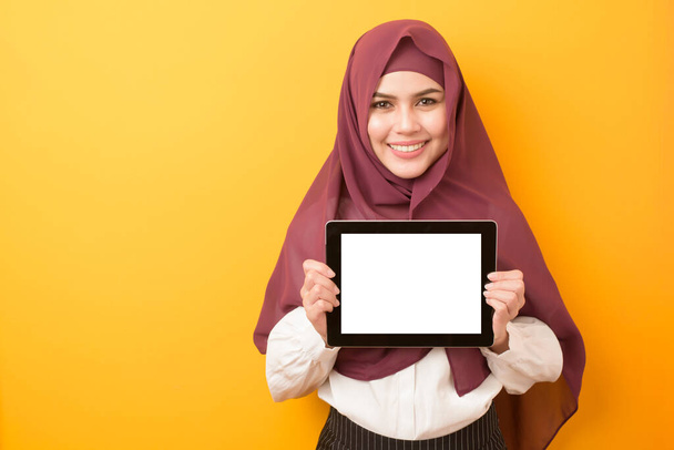 portrait of Beautiful University student is wearing hijab with tablet mockup on yellow background  - Photo, image
