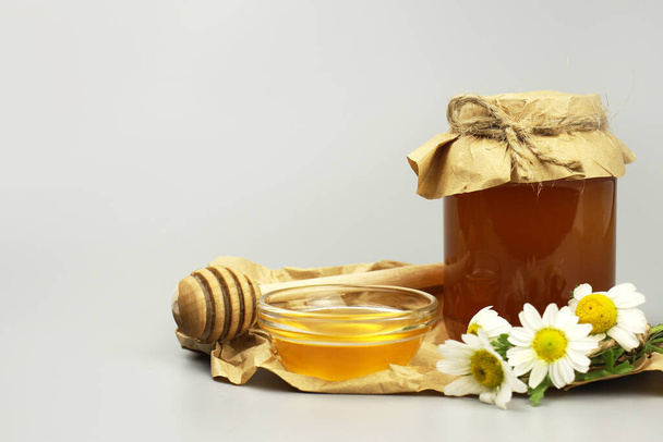 Miel en un frasco cubierto de papel y flores silvestres
 - Foto, Imagen