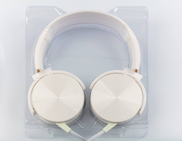 Stereo headphones. Top view of white headphones on white background with copy space. Flat lay. - Φωτογραφία, εικόνα