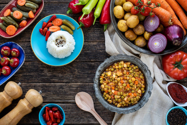 Veganistisch voedsel met bovenaanzicht zoals groene erwten, wortel, aardappelen en ui. Turkse voorgerecht zeytinyagli bezelye (groene erwten met olijfolie).  - Foto, afbeelding