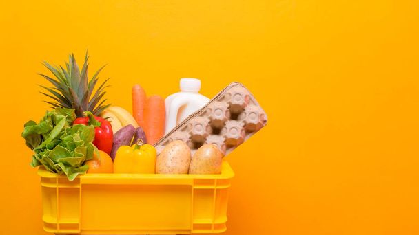 Set of delivery raw food in plastic box on yellow  background  - Foto, Bild