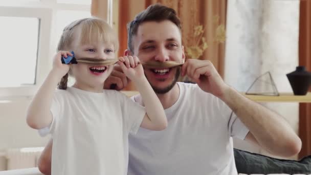 Αστείος πατέρας και η κόρη του κάνουν μουστάκι και ποζάρουν. Πατέρες έννοια ημέρα - Πλάνα, βίντεο