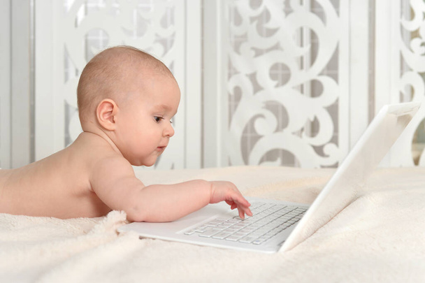 cute little baby boy on bed with laptop - Photo, Image