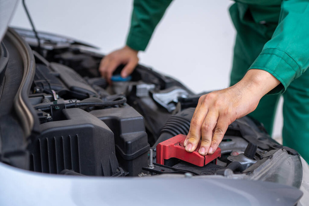 Professional mechanic hand providing car repair and maintenance service in auto garage. Car service business concept. - Фото, зображення
