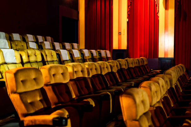 Gelbe Sitzreihe mit Popcorn auf Stuhl im Kinosaal - Foto, Bild