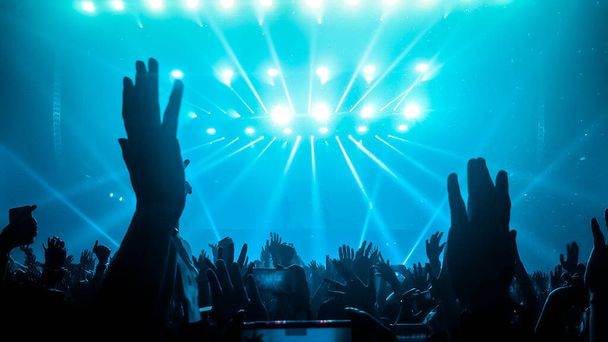 Happy people dansen in nachtclub DJ party concert en luisteren naar elektronische dansmuziek van DJ op het podium. Silhouet vrolijke menigte vieren Nieuwjaarsfeest 2020. Mensen levensstijl DJ nachtleven. - Foto, afbeelding