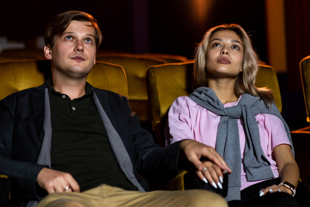 Caucasian lover enjoying to watch movie and eating popcorn together in the cinema - Фото, изображение
