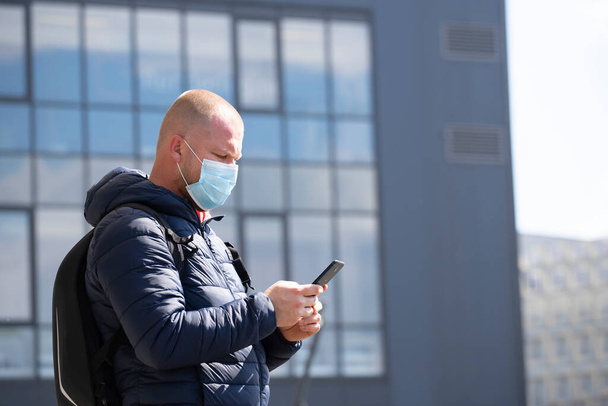 COVID-19 Pandemic Coronavirus. Tourist using the smartphone, wearing face mask protective for spreading of disease virus SARS-CoV-2.  - Foto, Imagen