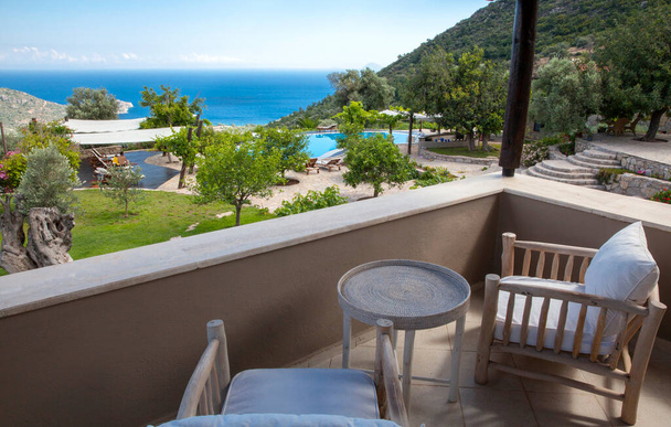 hermoso balcón, terraza con sillas y mesa. Hermoso paisaje de mar y montaña. Habitación de hotel y vista al resort
. , - Foto, imagen