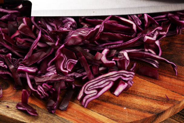 Cavolo rosso fresco tritato. Preparare verdure tagliate a fette per cucinare insalata di cavolo viola o insalata di cavolo. Cibo fresco fatto in casa concetto
. - Foto, immagini