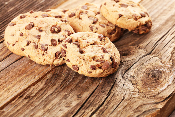 Chocolate cookies on wooden table. Chocolate chip cookies shot on wood - Photo, Image