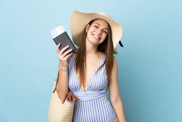 Young caucasian woman with pamela and holding passport isolated on blue background - Photo, Image