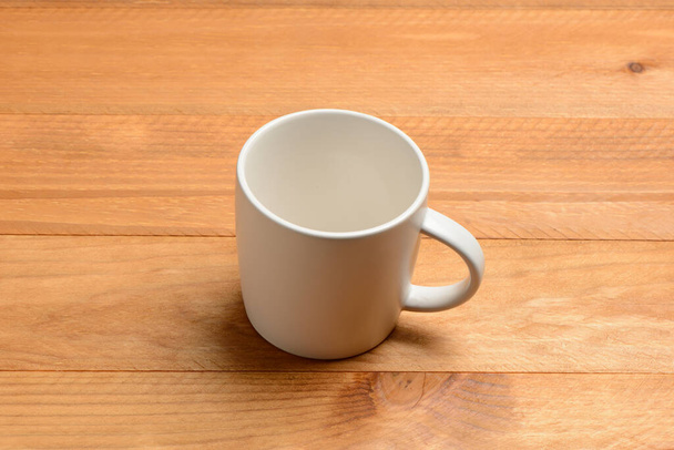 Empty white cup on wooden table - Fotografie, Obrázek