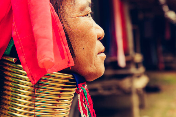 Retrato de pescoço longo mulher tecer pano na frente de sua casa na aldeia tribal norte da Tailândia
. - Foto, Imagem
