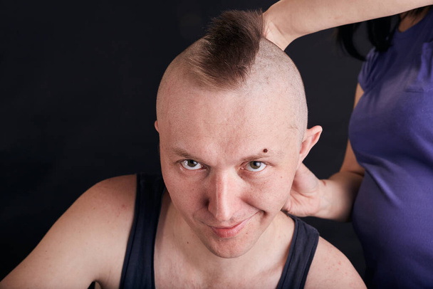 Vaimo tekee hiustenleikkuun miehelleen Covid-19:n karanteenin aikana. Self eristäminen perheen elämäntapa. - Valokuva, kuva