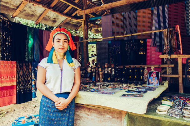 Long Neck Kobieta splot tkaniny przed domem w wiosce plemiennej północnej Tajlandii. - Zdjęcie, obraz