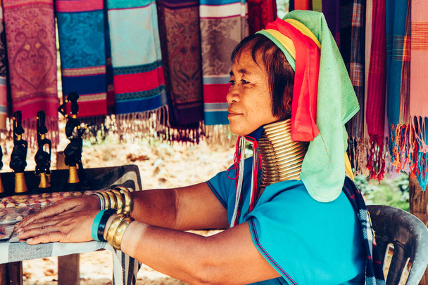 ロングネック女性は部族の村で彼女の家の前で布を織る北部タイ. - 写真・画像