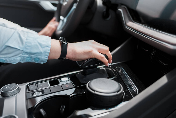 Business woman holds her hand on the gear selector automatic transmission - Fotó, kép