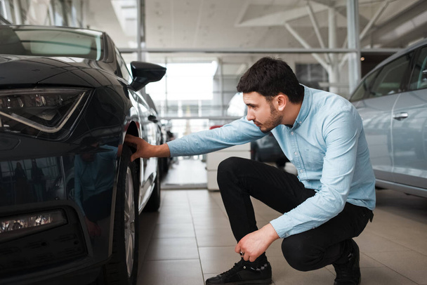 Un homme d'affaires inspecte une nouvelle voiture chez un concessionnaire - Photo, image